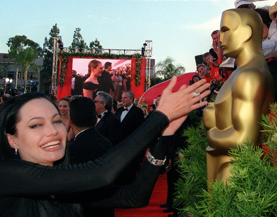 Jolie se acerca a tocar la estatua del premio Oscar en el año 2000, un gesto que le dio suerte ya que se hizo con el galardón por 'Inocencia interrumpida' (1999). (Foto: AMPAS / Getty Images)