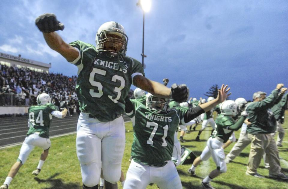 Richwoods players celebrate a 43-41 double-overtime victory over Lemont in a 2011 Class 6A state semifinal game at Richwoods Stadium.