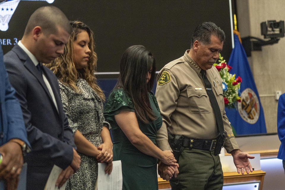 New Los Angeles County Sheriff Robert Luna, right, holds the hand of his wife as they pray with their family before Luna is sworn in as the 34th Los Angeles Sheriff during a ceremony in Los Angeles, Saturday, Dec. 3, 2022. (AP Photo/Damian Dovarganes)