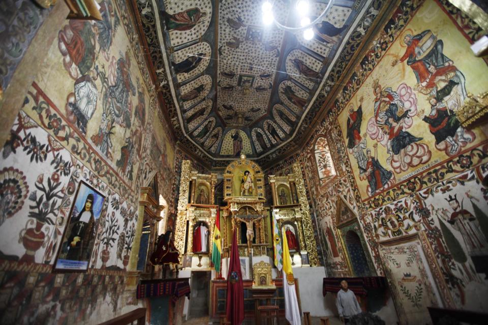 A boy walks in front of the altar in the Sistine Chapel of Los Andes in Curahuara de Carangas, Oruro department, 260 km. (160 miles) south from La Paz, Bolivia, Saturday, Dec. 8, 2012. Although a far cry from the original Sistine Chapel at the Vatican, the colorful paintings that decorate the inside of this small church built in 1608 to evangelize indigenous Bolivians into the Roman Catholic faith make it a popular choice for special religious services. (AP Photo/Juan Karita)