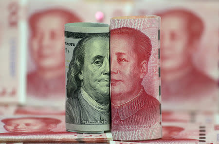 FILE PHOTO: A U.S. 100-dollar banknote featuring American founder Benjamin Franklin and a Chinese 100-yuan banknote featuring late Chinese chairman Mao Zedong are seen in this picture illustration taken January 21, 2016. REUTERS/Jason Lee/Illustration/File Photo