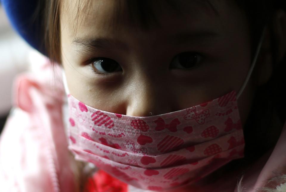 A girl wearing a mask sits in a school bus heading to the Emporium kindergarten in Koriyama, west of the tsunami-crippled Fukushima Daiichi nuclear power plant, Fukushima prefecture February 28, 2014. (REUTERS/Toru Hanai)