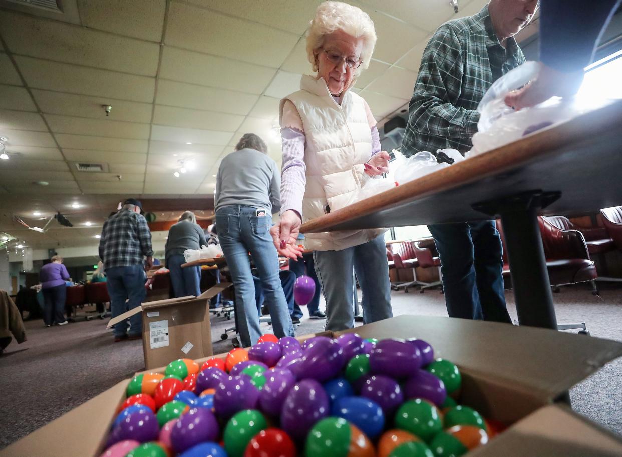 Colleen Alsteen drops a filled plastic egg into the box as she and fellow Bremerton Elks Lodge members fill 6,000 plastic eggs with candy for their upcoming egg hunt, on Wednesday, March 27, 2024.