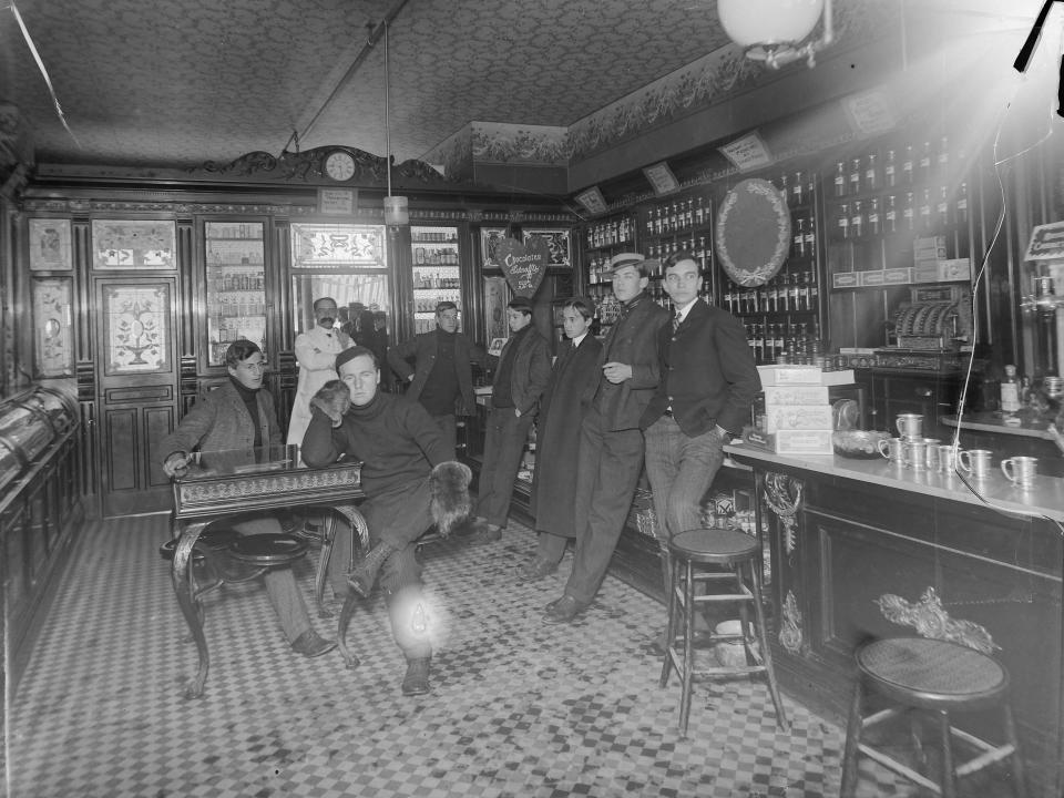Druggist Joseph Knight keeps a close eye on a group of Academy boys. His drugstore, like most, featured both pharmaceuticals and a soda fountain (seen on right) in 1904.