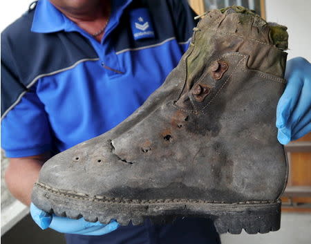 A police officer displays a shoe found in September 2014 near the Matterhorn mountain in Zermatt, Switzerland, in this handout picture released on August 6, 2015 by the Police Cantonale Valaisanne. REUTERS/Police Cantonale Valaisanne/Handout via Reuters