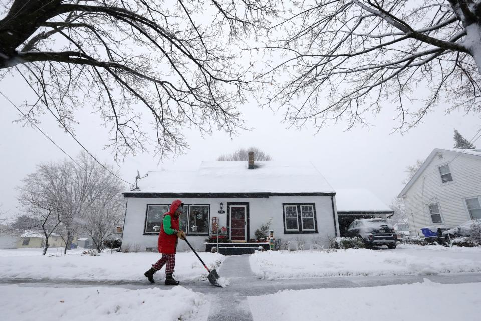 Kelly-Jo St. Aubin clears snow from the sidewalk at her home during a snowstorm Tuesday, January 9, 2024, in Kaukauna, Wisconsin.