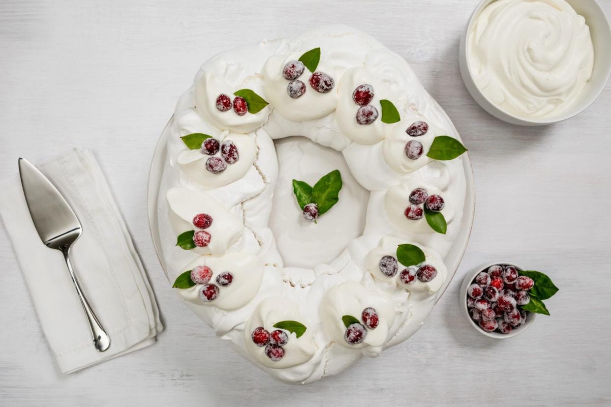 This pavlova Christmas Wreath adorned with sugared cranberries is sure to stun your Christmas guests.