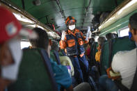 A member of the Venezuelan civil protection agency explains commuters symptoms and preventive measures for the new coronavirus in Caracas, Venezuela, Sunday, March 15, 2020. Venezuela announced quarantine measures in six states and in Caracas. The vast majority of people recover from the new virus. (AP Photo/Matias Delacroix)