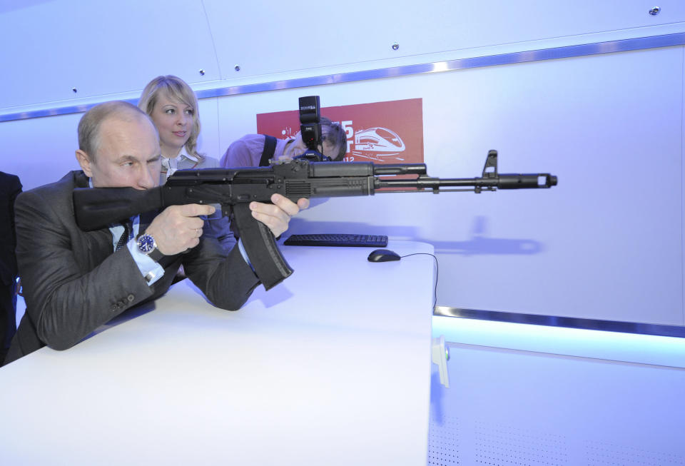 Putin takes aim with a model assault rifle at an electronic shooting range during his visit to a research facility of the&nbsp;national railway company in Moscow on April 26, 2012.