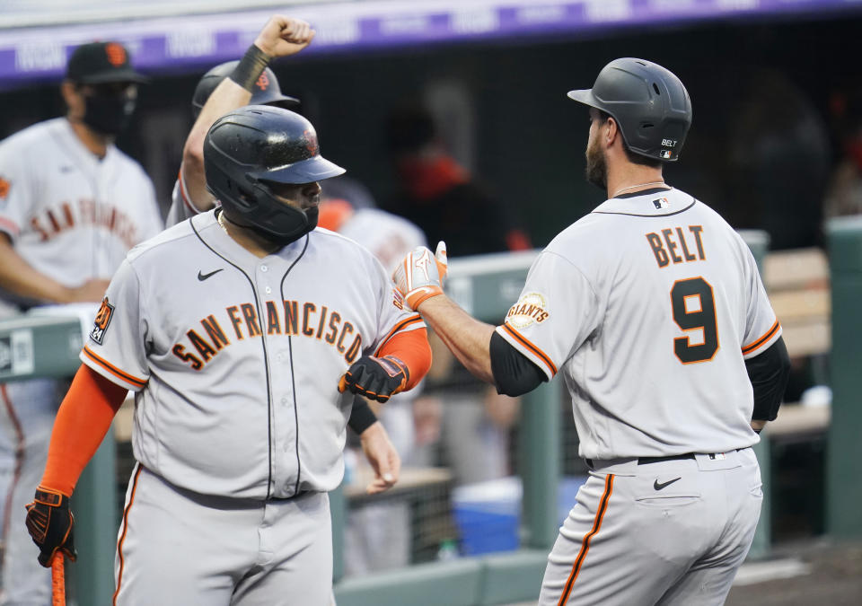 San Francisco Giants' Brandon Belt (9) is congratulated by Pablo Sandoval (48) after hitting a three-run home run against the Colorado Rockies during the fourth inning of a baseball game, Wednesday, Aug. 5, 2020, in Denver. (AP Photo/Jack Dempsey)