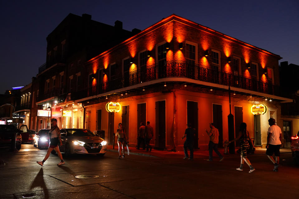 In the aftermath of Hurricane Ida, people walk across Bourbon Street, Saturday, Sept. 4, 2021, in the French Quarter of New Orleans. (AP Photo/Matt Slocum)