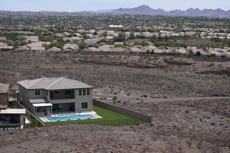 FILE - A home with a swimming pool abuts the desert on the edge of the Las Vegas valley, Wednesday, July 20, 2022, in Henderson, Nev. The U.S. Bureau of Reclamation is expected to publish hydrology projections on Tuesday, Aug. 16, 2022, that will trigger agreed-upon cuts to states that rely on the river. (AP Photo/John Locher, File)