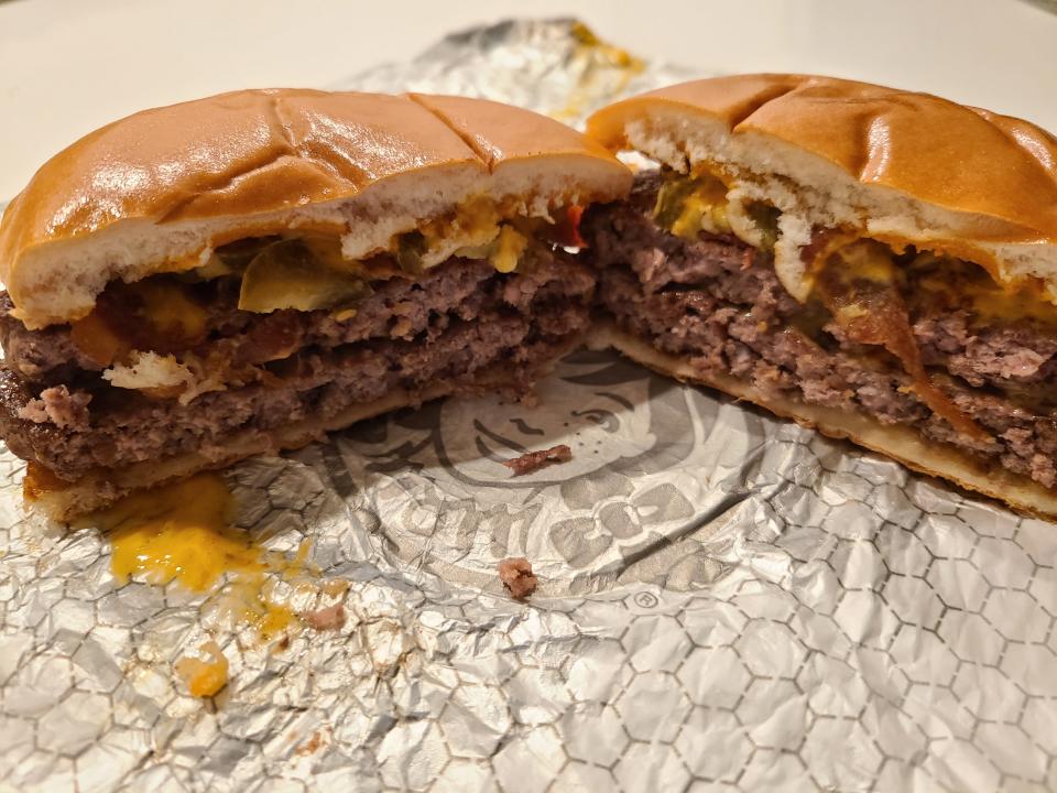 wendys bacon jalepeno double cheeseburger cut in half on white wrapper