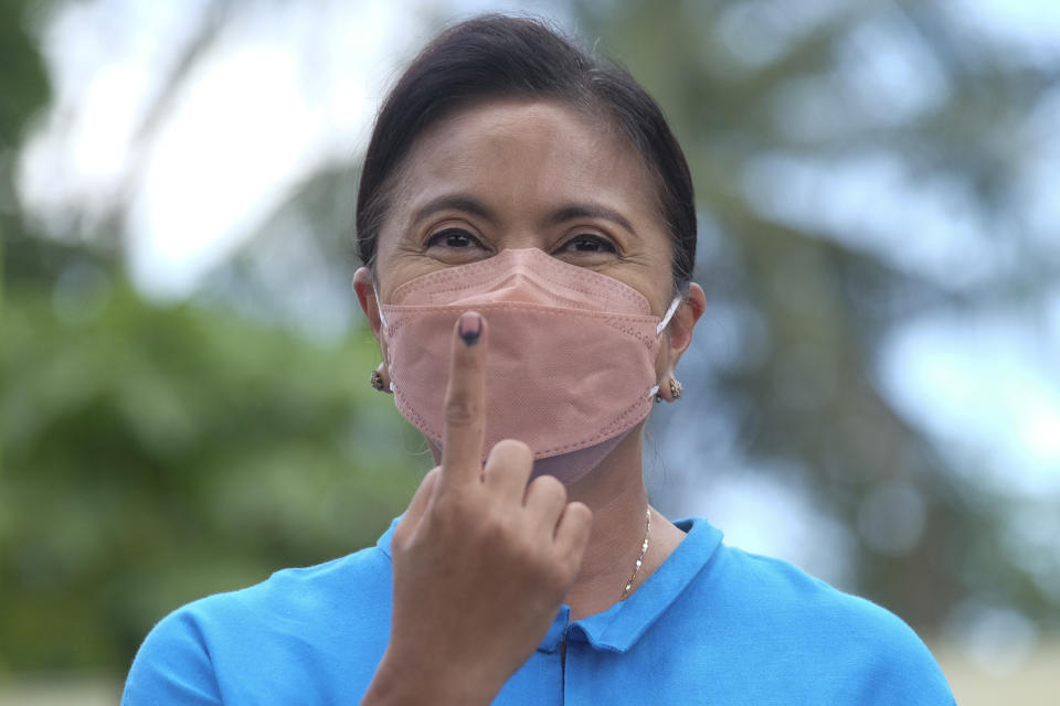 CORRECTS PLACE - Presidential candidate and incumbent Vice President Leni Robredo shows the ink on her finger to mark that she has finished voting at a school used as a polling center in Camarines Sur, eastern Philippines on Monday, May 9, 2022. Filipinos were voting for a new president Monday, with the son of an ousted dictator and a champion of reforms and human rights as top contenders in a tenuous moment in a deeply divided Asian democracy. (AP Photo/Zalrian Sayat)