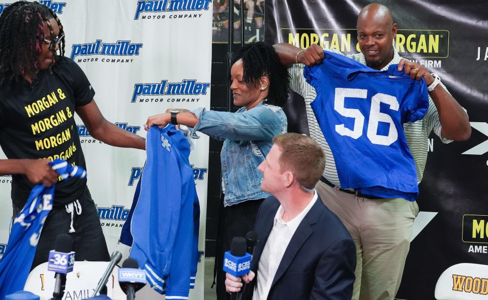 Jasper Johnson, left, a Lexington native and one of the top basketball players in the 2025 high school class, was given a jacket by his mom Nyoka Johnson as his dad Dennis Johnson looked on at right, as he announces his commitment to the University of Kentucky during a ceremony at the Woodford County High School in Versailles, Ky. on Sep. 5, 2024.