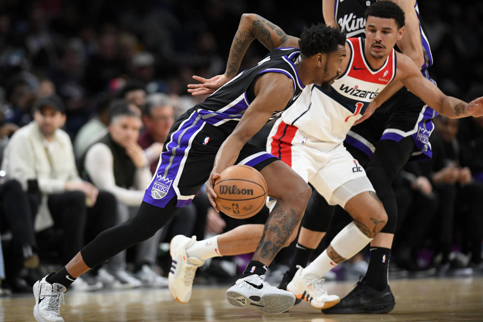 Sacramento Kings guard Malik Monk, left, drives past Washington Wizards guard Johnny Davis during the first half of an NBA basketball game Thursday, March 21, 2024, in Washington. (AP Photo/John McDonnell)