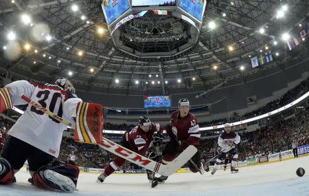 Goalie Tim Thomas of the U.S. is challenged by Latvia's Herberts Vasiljevs and Martins Cipulis (L-R) during their men's ice hockey World Championship Group B game at Minsk Arena in Minsk May 15, 2014. REUTERS/Alex Kudenko/Pool