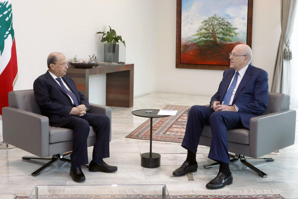In this photo released by Lebanese government, Lebanese President Michel Aoun, left, meets with Prime Minister Najib Mikat, at the presidential palace, in Baabda, east of Beirut, Lebanon, Friday, Sept 10, 2021. Lebanese factions formed a new government on Friday, breaking a 13-month deadlock that saw the country slide deeper into financial chaos and poverty. (Dalati Nohra/Lebanese Official Government via AP)