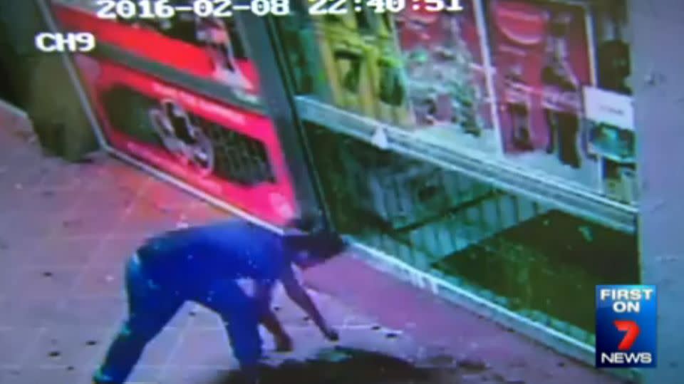 The 19-year-old throws bricks repeatedly into the window of the shops. Photo: 7 News