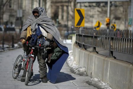 A homeless man makes his way through the Brooklyn bridge during low temperatures at Lower Manhattan in New York, in this February 20, 2015, file photo. REUTERS/Eduardo Munoz/Files