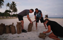 <p>People, who declined to be named, fill up sand bags that will be used to help protect their home in preparation for Hurricane Lane, Wednesday, Aug. 22, 2018, along Ewa Beach in Honolulu. (Photo: John Locher/AP) </p>