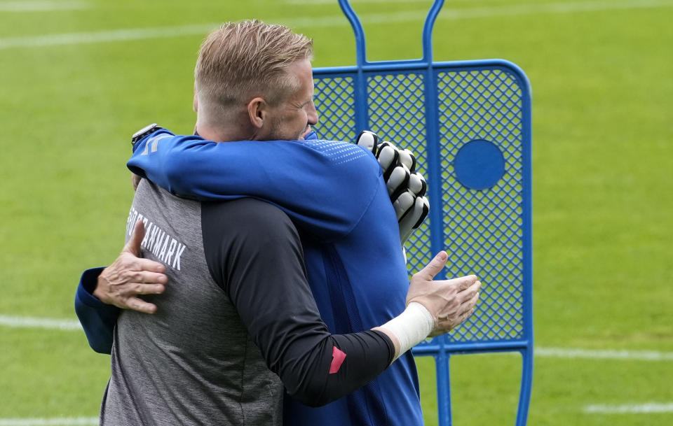 Denmark's goalkeeper Kasper Schmeichel is embraced at the training ground during a training session of Denmark's national team in Helsingor, Denmark, Monday, June 14, 2021. It is the first training of the Danish team since the Euro championship soccer match against Finland when Christian Eriksen collapsed last Saturday. (AP Photo/Martin Meissner)