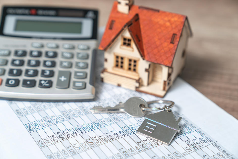 keys, toy home, and calculator on the table