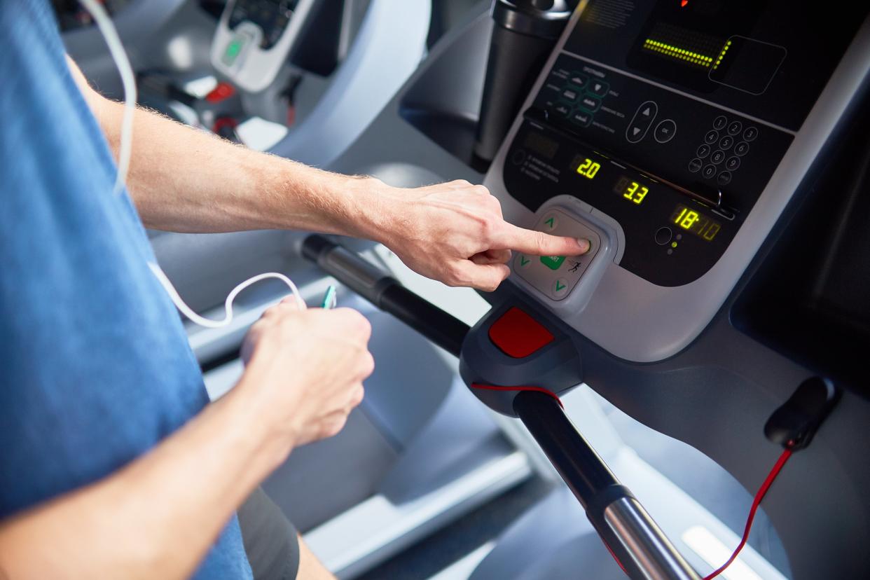 closeup of man setting exercise machine in gym