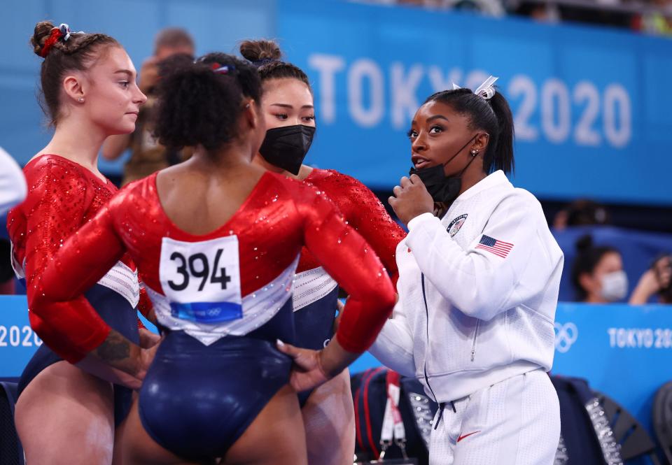 Simone Biles speaks with her Olympic teammates.