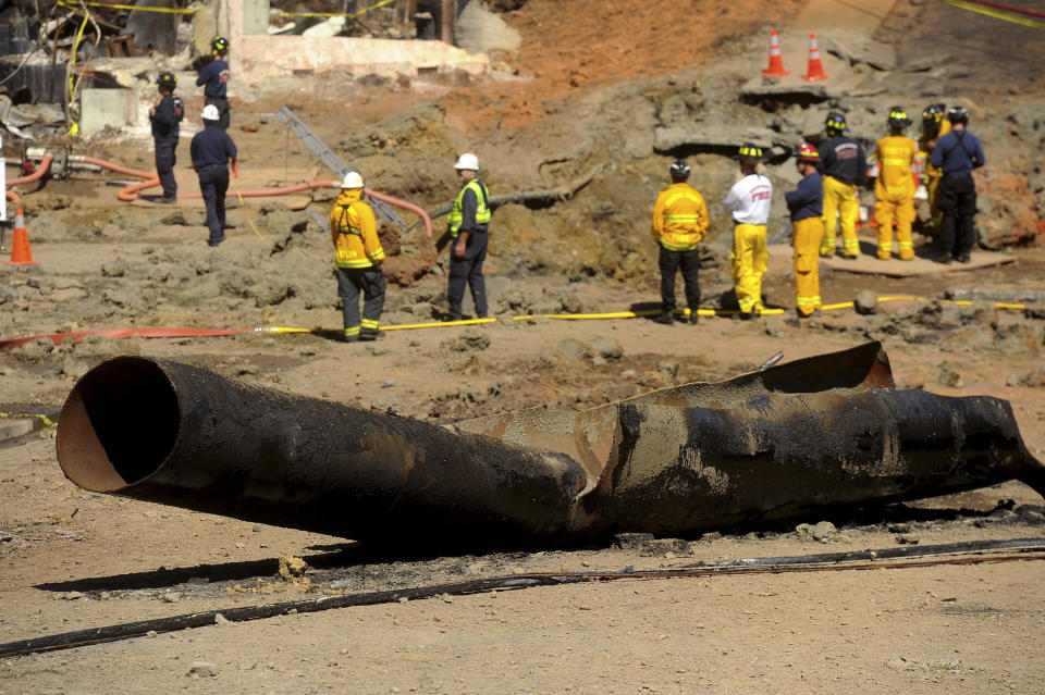 FILE - In this Sept. 11, 2010, file photo, a Pacific Gas & Electric natural gas line lies broken on a San Bruno, Calif., road after a massive explosion. U.S. prosecutors are urging a federal judge to work with a court-appointed monitor to determine ways Pacific Gas & Electric Co. can prevent its equipment from starting more wildfires. District Judge William Alsup overseeing Pacific Gas & Electric's criminal probation is holding a hearing Tuesday, May 4, 2021, to consider whether Pacific Gas & Electric violated its criminal probation from a fatal 2010 natural gas explosion by sparking the October 2019 Kincade Fire north of San Francisco.(AP Photo/Noah Berger, File)