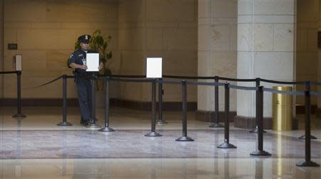 A Capitol Hill policeman adjusts signs meant for tourists to queue up during their visit to the U.S. Capitol Visitors Center in Washington, October 9, 2013. REUTERS/Jason Reed