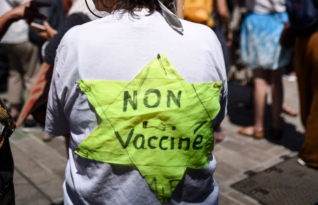 Une manifestante osant le parallèle entre le pass sanitaire et l'étoile jaune imposée aux juifs pendant la seconde guerre mondiale lors de la manifestation du 17 juillet.  (Photo: SEBASTIEN SALOM-GOMIS via AFP)