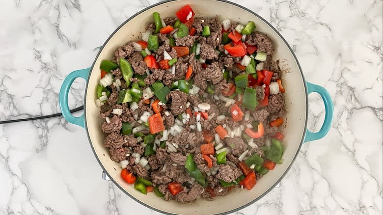 cooking ground beef, peppers, and onions