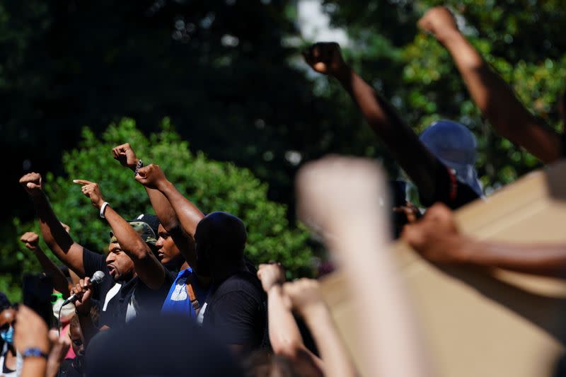 People raise their fists during a rally against racial inequality and the police shooting death of Rayshard Brooks, in Atlanta