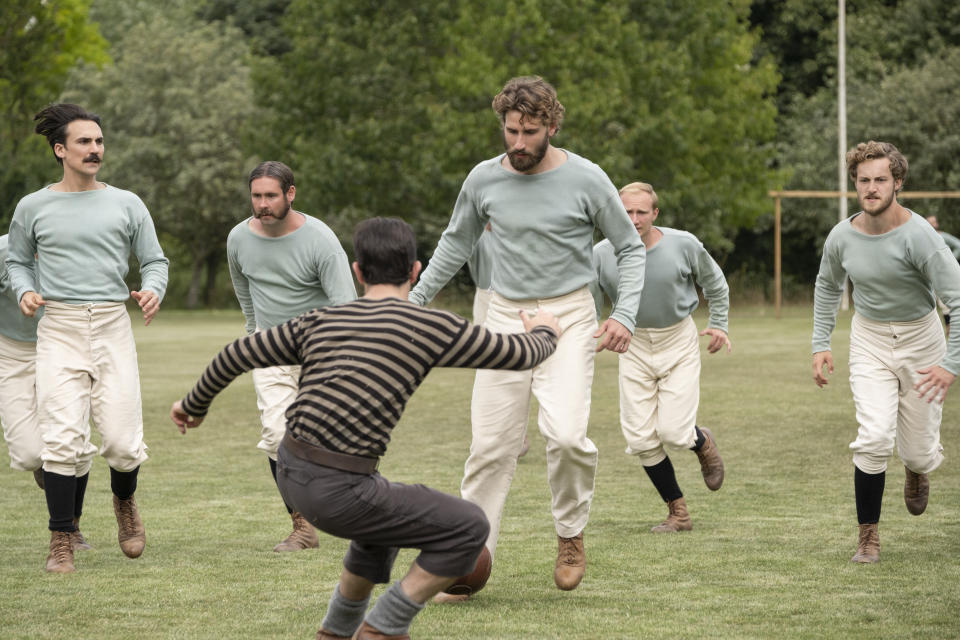 This image released by Netflix shows Kevin Guthrie, foreground center, and Edward Holcroft, background center, in a scene from "The British Game," a six-part drama charting the origins of soccer. (Oliver Upton/Netflix via AP)