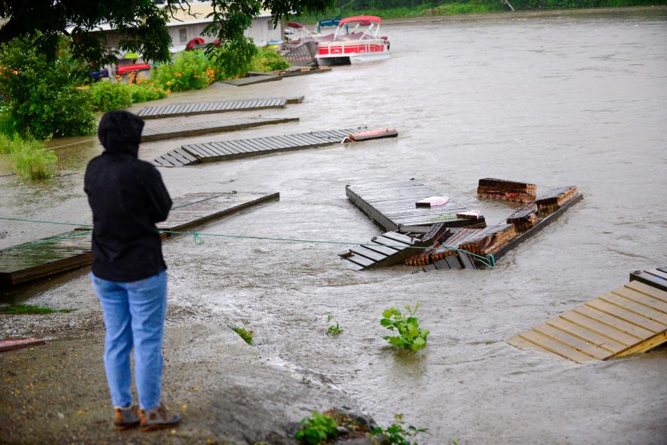 People look as as docks and boats are washed away on the West River in Brattleboro, Vt., near The Marina, Monday, July 10, 2023. (Kristopher Radder/The Brattleboro Reformer via AP)