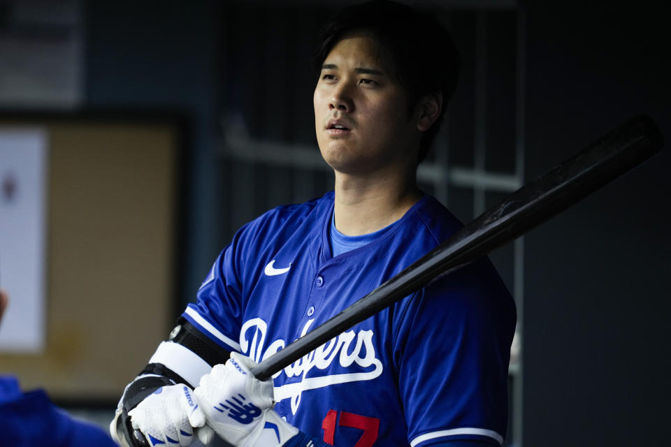 Los Angeles Dodgers designated hitter Shohei Ohtani (17) prepares his bat in the dugout during the first inning of a spring training baseball game against the Los Angeles Angels in Los Angeles, Sunday, March 24, 2024. (AP Photo/Ashley Landis)