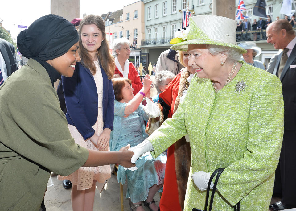 Britain's Queen Elizabeth II shakes hands with Nadiya Hussein (L), winner of the Great British Bake Off who baked a cake for her during a 'walkabout' on her 90th birthday in Windsor, west of London, on April 21, 2016.  Britain celebrates Queen Elizabeth II's 90th birthday on Thursday, with her eldest son Prince Charles paying tribute in a special radio broadcast and Prime Minister David Cameron leading a parliamentary homage. / AFP / POOL / John Stillwell        (Photo credit should read JOHN STILLWELL/AFP via Getty Images)