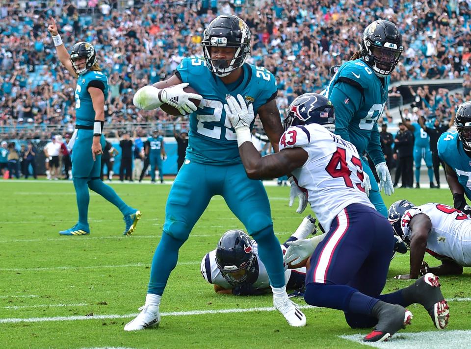 Jaguars quarterback Trevor Lawrence (16) celebrates as running back James Robinson (25) goes into the end zone for a touchdown against the Texans in December.