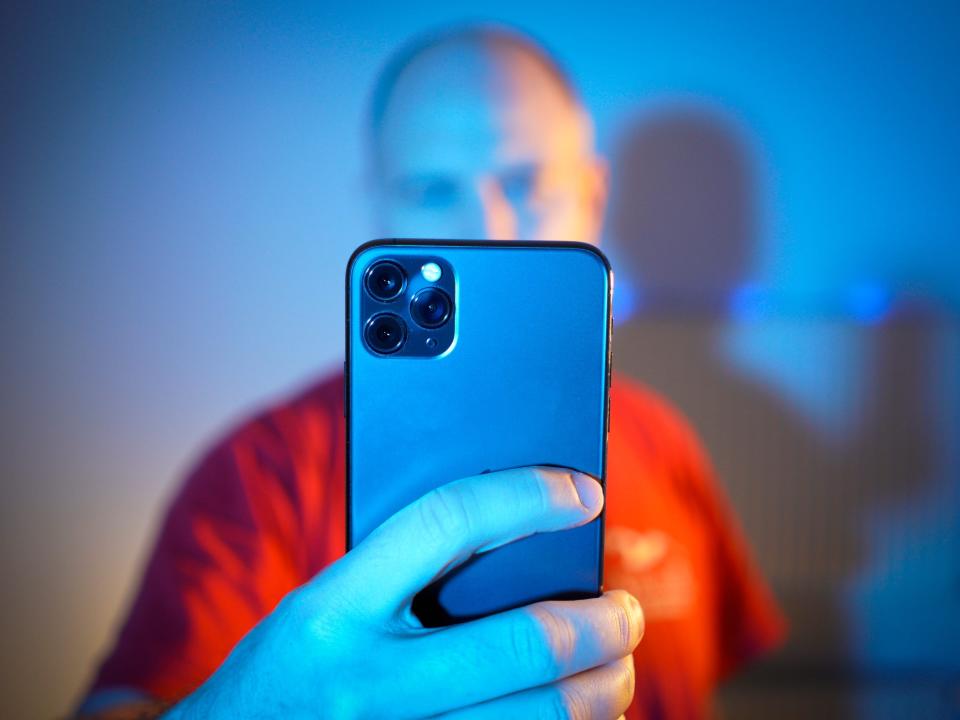 A stock image of a man seen looking at an Apple iPhone 11 Pro Max tin The Hague on March 2, 2020