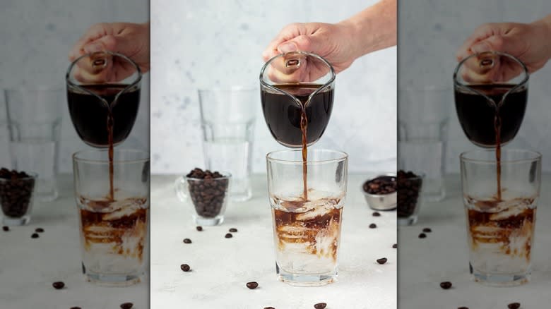 Person pouring espresso into tonic water