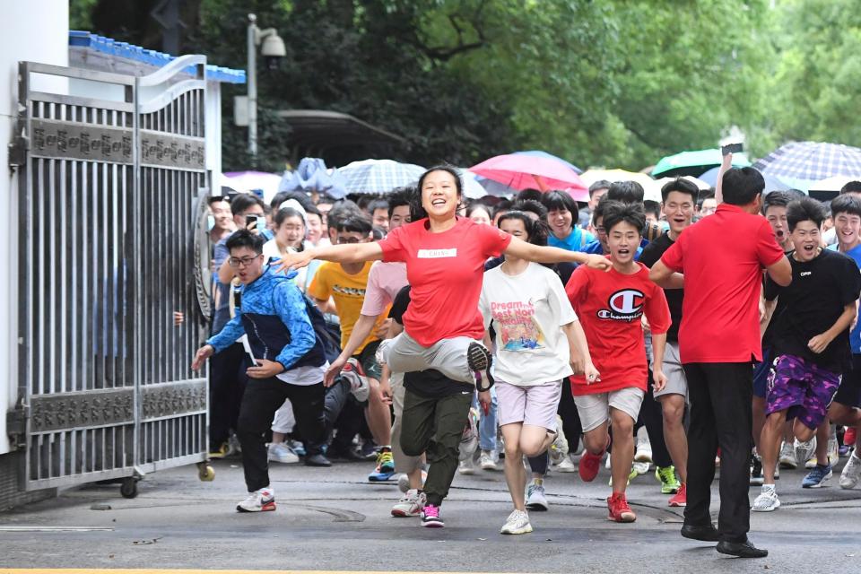 Examinees rush out of an exam site after the final subject of the 2020 National College Entrance Examination (aka Gaokao) on July 8, 2020 in Changsha, Hunan Province of China.