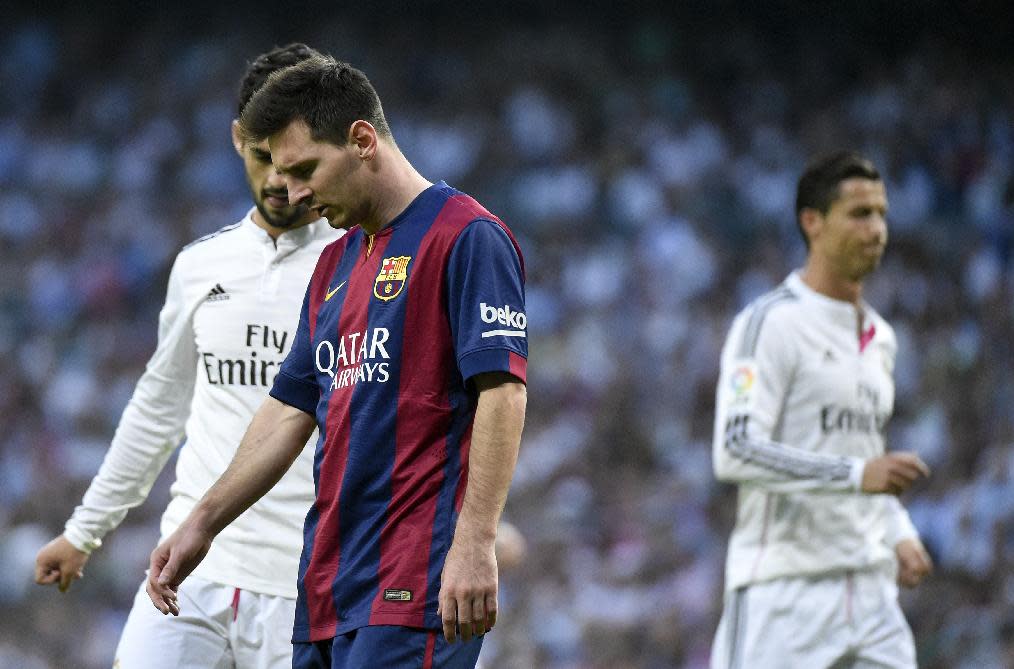 La estrella argentina del Barcelona, Lionel Messi (I), se muestra cabizbajo en la derrota 3-1 de su equipo ante el Real Madrid, el 25 de octubre de 2014, en el Santiago Bernabéu, en Madrid (AFP | GERARD JULIEN)