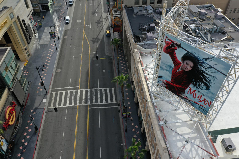 A poster of the Walt Disney Studios' "Mulan" movie, which was going to be released on March 27, towers over an empty Hollywood Boulevard during the global outbreak of coronavirus disease (COVID-19), in Hollywood, Los Angeles, California, U.S., March 31, 2020.  REUTERS/Lucy Nicholson