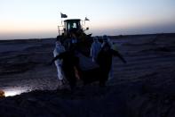 Members of the Popular Mobilization Forces (PMF) bury people who passed away due to coronavirus disease (COVID-19) at the new Wadi Al-Salam cemetery on the outskirts of the holy city of Najaf