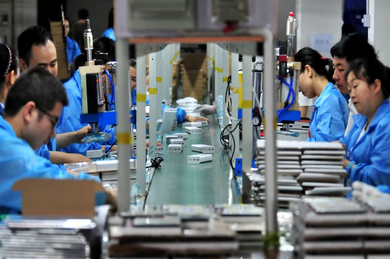 FILE PHOTO: Employees work on a production line manufacturing lithium battery products at a factory in Yichang, Hubei