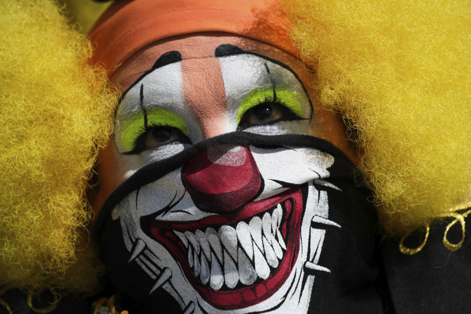 A clown in a face mask protests restrictions to contain the spread of COVID-19 which bar clowns from working on the streets outside the National Palace in Mexico City, Thursday, April 30, 2020. (AP Photo/Fernando Llano)