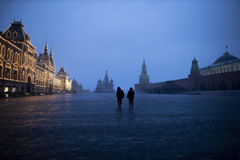 FILE In this file photo taken on Monday, March 30, 2020, two police officers patrol an almost empty Red Square, with St. Basil's Cathedral, center, and Spasskaya Tower and the Kremlin Wall, right, at the time when its usually very crowded in Moscow, Russia. Russian President Vladimir Putin has ordered the postponement of a Victory Day parade marking the 75th anniversary of the end of World War II, citing the ongoing public health threat from the coronavirus pandemic. Speaking in televised remarks on Thursday, April 16, 2020, Putin said the festivities would be held later this year. (AP Photo/Alexander Zemlianichenko, File)