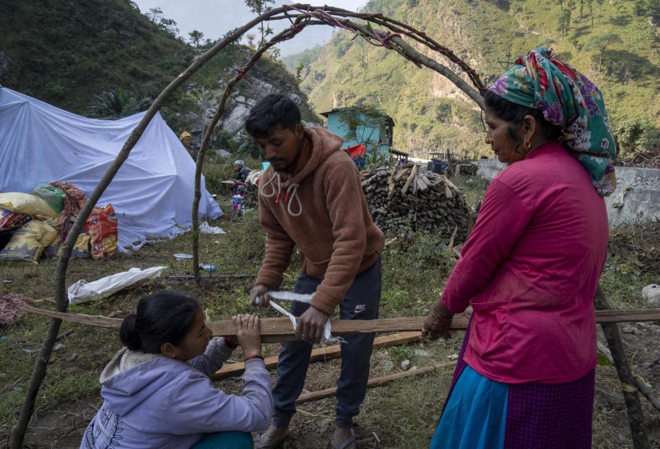 Survivors make a temporary shelter near their earthquake damaged houses in Rukum District, northwestern Nepal, Monday, Nov. 6, 2023. The Friday night earthquake in the mountains of northwest Nepal killed more than 150 people and left thousands homeless. (AP Photo/Niranjan Shrestha)