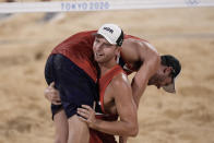 Anders Berntsen Mol, top, of Norway, is carried by teammate Christian Sandlie Sorum, celebrate winning a men's beach volleyball semifinal match against Latvia at the 2020 Summer Olympics, Thursday, Aug. 5, 2021, in Tokyo, Japan. (AP Photo/Petros Giannakouris)